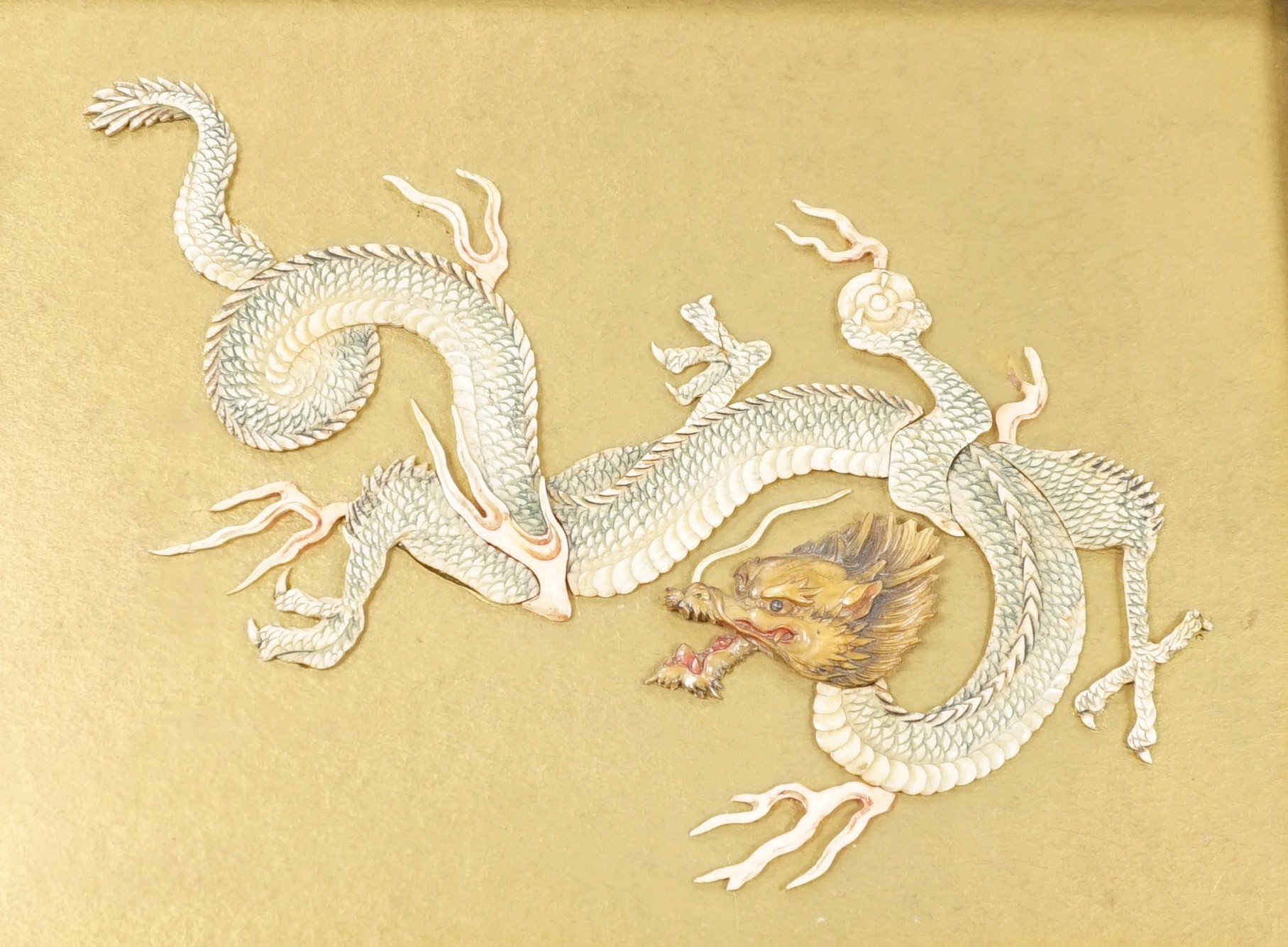A Japanese bone ‘dragon’ and lacquer framed panel, early 20th century, 31 x 37 cm